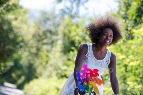 Visualização: linda jovem afro-americana andando de bicicleta na floresta