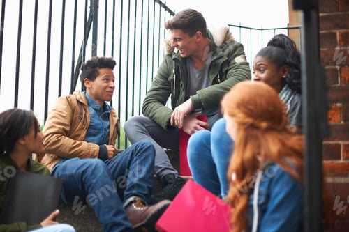 Preview: Young adult college student friends chatting and revising on campus stairs
