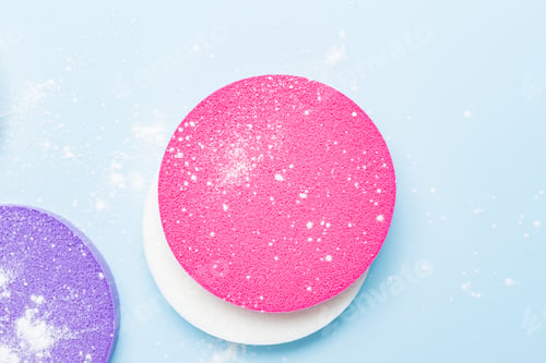 Preview: Cosmetic sponge and dusted transparent mineral powder on a blue background. The concept of makeup