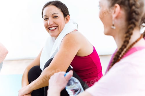 Preview: Couple relaxing on yoga mat and talking after workout session.