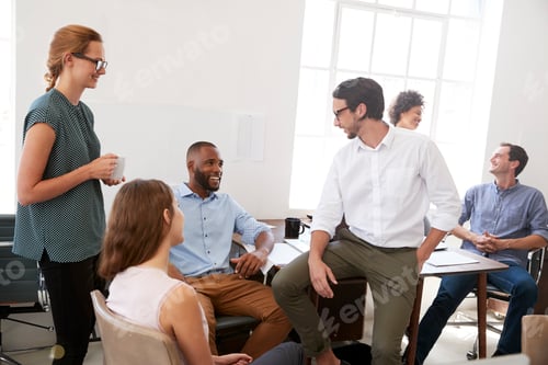 Preview: Colleagues enjoying a casual meeting in their office, close up
