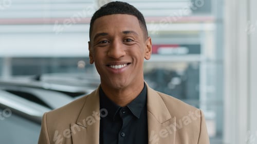 Preview: Close up African American man ethnic male dealer salesman seller trader in auto store showroom happy