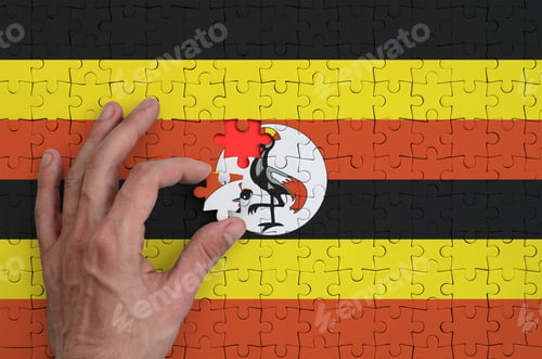 Preview: Uganda flag is depicted on a puzzle, which the man's hand completes to fold.