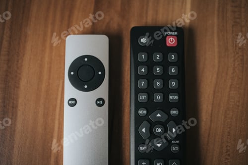 Preview: Top view shot of two different remote controls of TV on a wooden background.