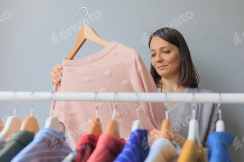 Preview: happy woman chooses clothes in wardrobe or store, shopping