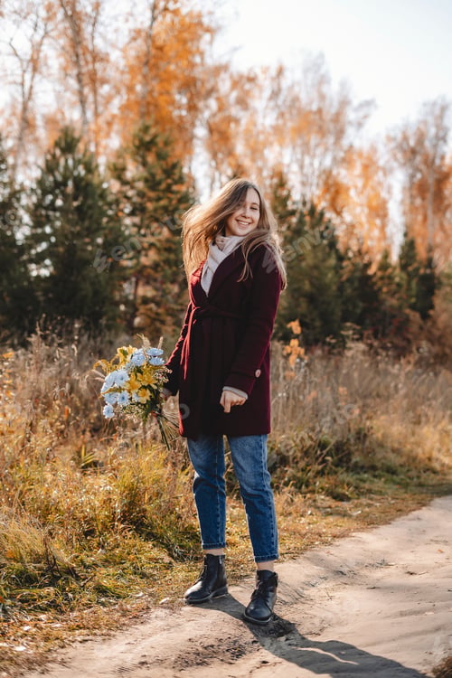 Preview: Woman with bouquet of flowers in an autumn park