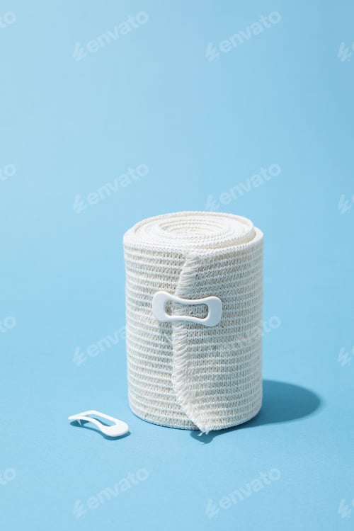Preview: Concept of help during an injury, elastic bandage on blue background