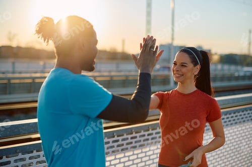 Athletic Man and Woman Giving High Five Outdoors