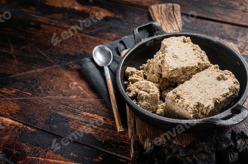 Preview: Halva with sunflower seeds and honey in pan. Wooden background. Top view. Copy space