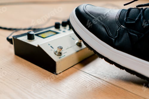 Preview: musician's male foot pressing bass drum pedal or bass electric guitar in recording studio close-up