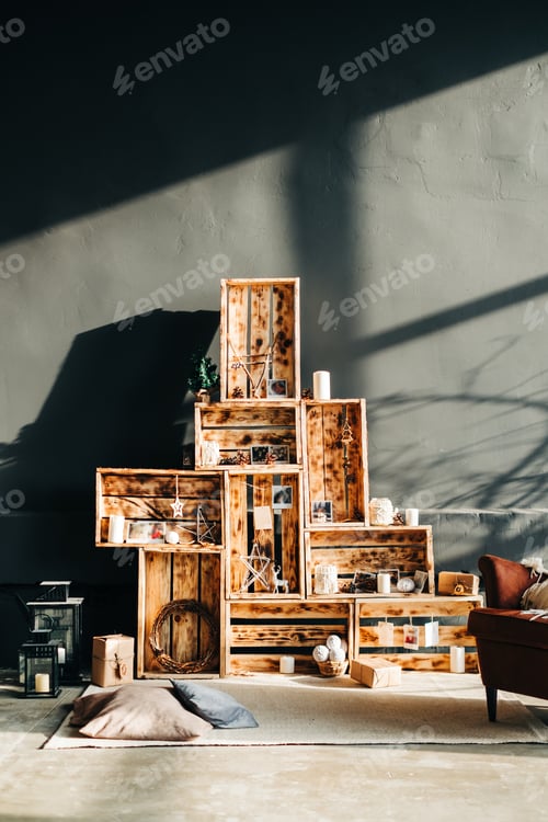 Preview: Interior of living room with decorative Christmas wooden boxes in sunlight.