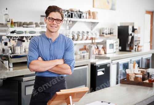 Preview: Male coffee shop owner behind the counter, arms crossed