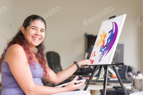 Preview: Painting at home, weekend leisure hobby. Happy smiling south american venezuelan middle aged woman