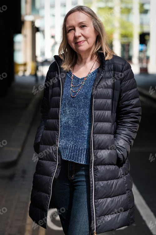 Preview: Mature blonde woman poses looking to camera.