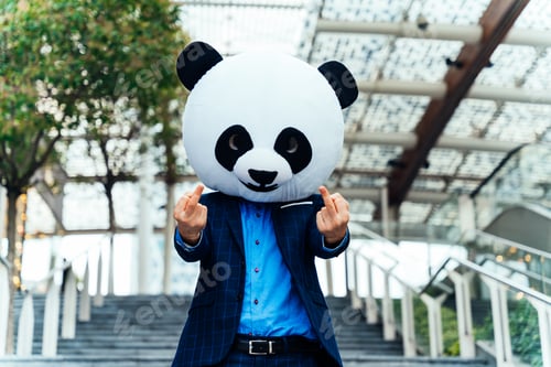 Preview: Storytelling image of a business man wearing a giant panda head