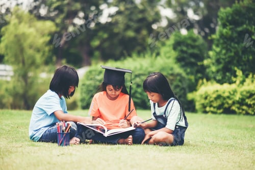 Preview: Group of children lying reading on grass field