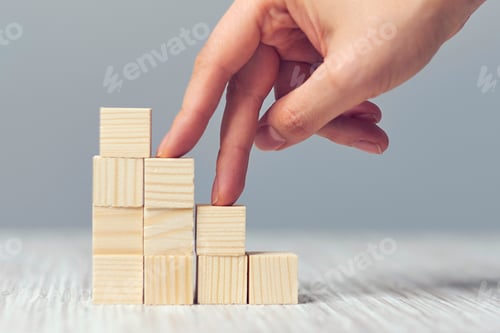 Preview: Stacked cubes and female hand imitating walking upstairs against white background.