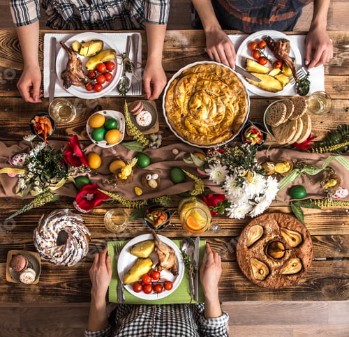 Preview: Holiday friends or family at the holiday table with rabbit meat, vegetables, pies, eggs, top view.