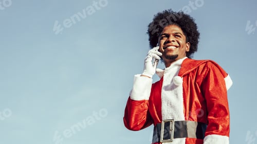 Preview: Close-up portrait of black ethnicity afro santa talking on the phone