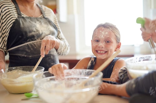 Preview: Getting messy is half the fun. Shot of two little girls baking with their mother in the kitchen.