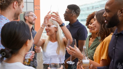Preview: Multi-Cultural Business Team Meeting Outdoors For After Work Drinks On Office Rooftop Or Bar