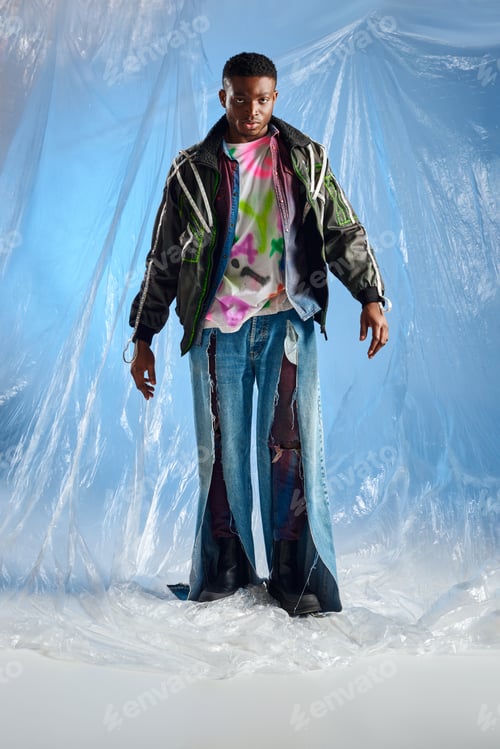 Preview: Full length of fashionable young afroamerican man in outwear jacket with led stripes and jeans