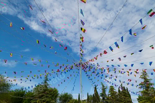 Preview: colorful pennants flags hanging over blue sky. Festival or party concept