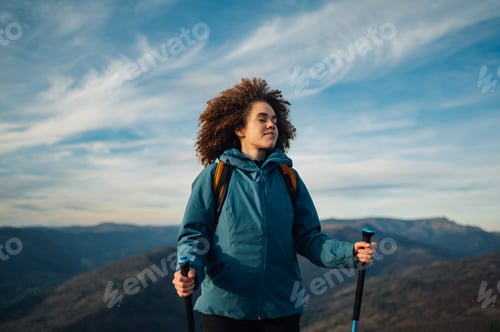 Preview: Hiker breathing fresh air on mountain top at sunset