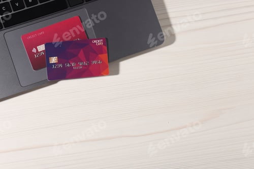 Preview: Online payment. Credit cards and laptop on light wooden table, top view. Space for text