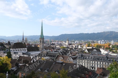 Preview: Breathtaking view of Zurich buildings and the surrounding countryside with blue cloudy sky