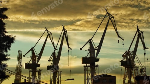 Preview: Building construction cranes silhouettes with sunset sky background