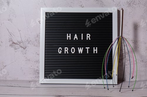 Preview: Scalp massager for home with letter board HAIR GROWTH text. Close up of scalp massaging brush for
