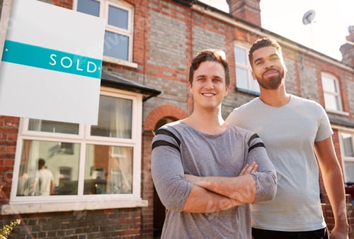 Preview: Portrait Of Two Men Standing Outside New Home With Sold Sign