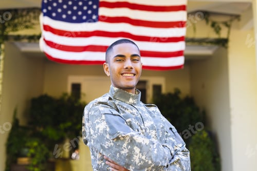 Preview: Portrait of happy biracial male american soldier wearing military uniform standing outside the house