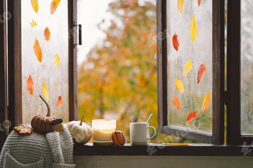 Preview: Still life details in home on a wooden window. Sweater, candle, hot tea and autumn decor