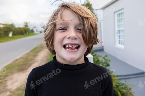 Preview: Eight year old boy with a nut between his teeth, a toothy grin