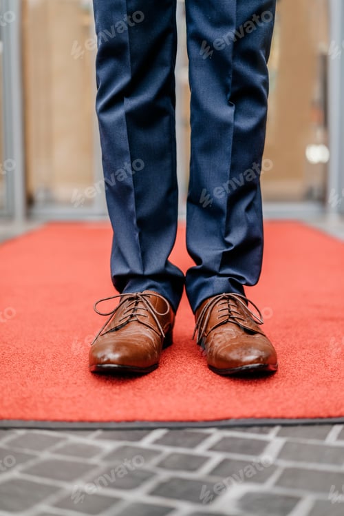 Vista previa: Empresario de pie en la alfombra roja, vista parcial