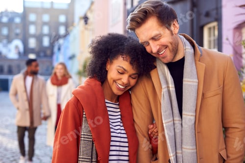 Preview: Multi Cultural Couple With Friends Walking Along Residential City Street In Fall Or Winter