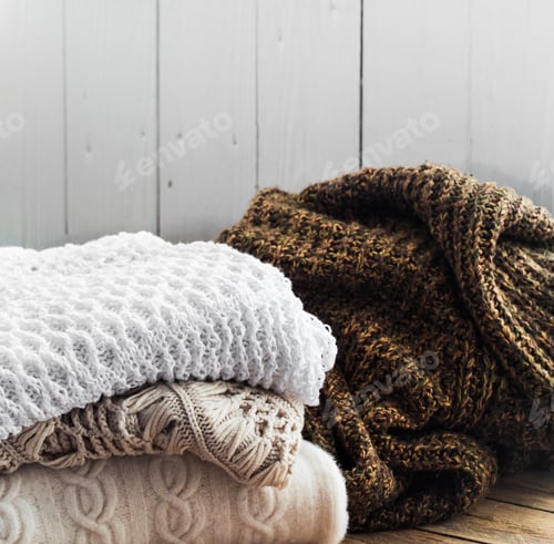Preview: Knitted cosy sweater lying on wooden background