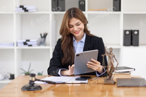 Preview: Attractive young lawyer in office Business woman and lawyers discussing contract papers with brass