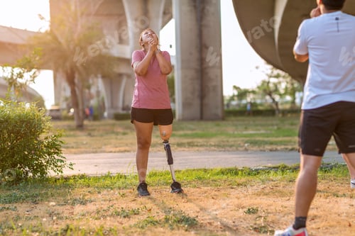 Preview: Friend support Friend with a prosthetic leg while exercising outdoor.