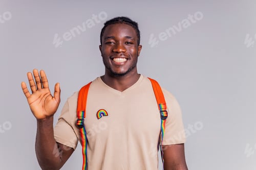 Preview: polyethnic man in beige t-shirt with an orange backpack holding book and notebooks