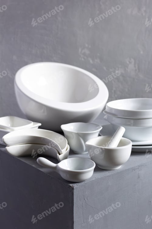 Preview: Empty crockery or ceramic dishes set. Kitchen dishware and tableware on grey near wall background
