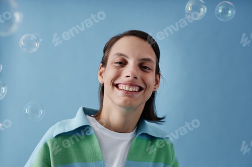 Preview: Girl with disability looking at camera smiling on blue background