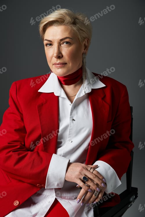 Preview: A stylish woman in elegant red attire poses confidently against a dark backdrop