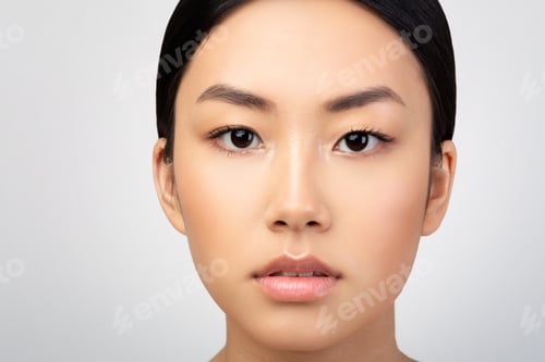 Preview: Closeup Of Asian Woman's Face With Makeup Over Gray Background