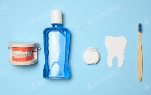 Preview: Plastic bottle with mouthwash, wooden toothbrush on blue background