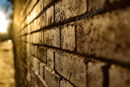 Preview: Brick wall background at sunset with sun rays, stone texture.