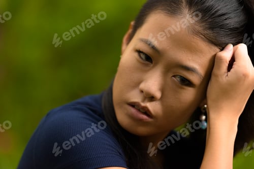 Preview: Close-up portrait of beautiful rebel Asian woman face outdoors