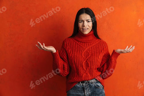 Preview: Hispanic displeased woman frowning and holding copyspace